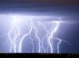 A dramatic night sky illuminated by multiple spectacular lightning strikes.